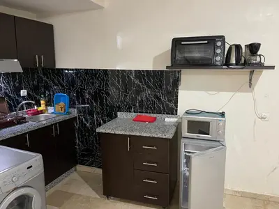 a small kitchen with a microwave on a shelf at Appartement 25 4èm étage ( POUR FAMILLE ) in Marrakech