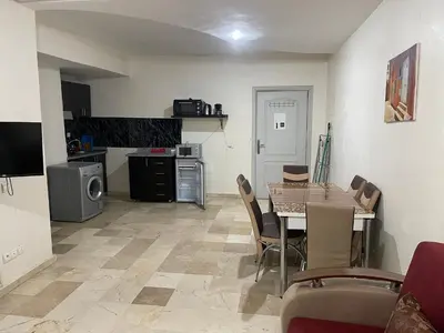 a kitchen and dining room with a table and chairs at Appartement 25 4èm étage ( POUR FAMILLE ) in Marrakech