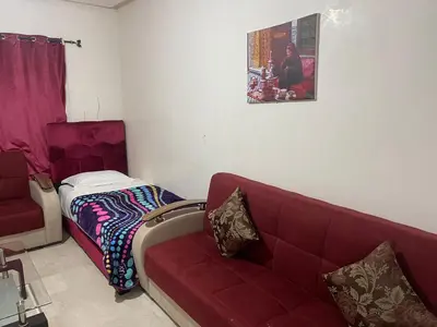 a living room with a couch and a bed at Appartement 26 au 4ème étage avec balcon ( POUR FAMILLE ) in Marrakech