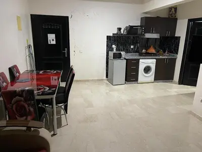 a kitchen with a table and a washing machine at Appartement 26 au 4ème étage avec balcon ( POUR FAMILLE ) in Marrakech