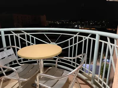 a table and chairs on a balcony at night at Appartement 26 au 4ème étage avec balcon ( POUR FAMILLE ) in Marrakech