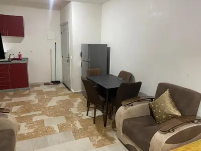 a kitchen with a table and chairs and a refrigerator at Appartement 27 au 4ème étage ( POUR FAMILLE ) in Marrakech