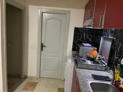a kitchen with a sink and a stove and a door at Appartement 27 au 4ème étage ( POUR FAMILLE ) in Marrakech