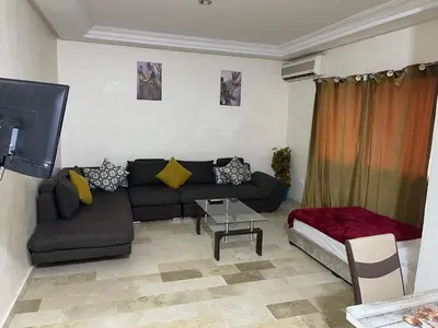 a living room with a couch and a table at Appartement 28 au 4 éme étage avec balcon ( POUR FAMILLE ) in Marrakech