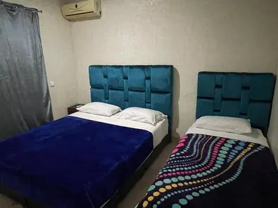 two beds with blue headboards in a room at Appartement 28 au 4 éme étage avec balcon ( POUR FAMILLE ) in Marrakech