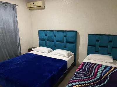 a bedroom with two beds with blue headboards at Appartement 28 au 4 éme étage avec balcon ( POUR FAMILLE ) in Marrakech