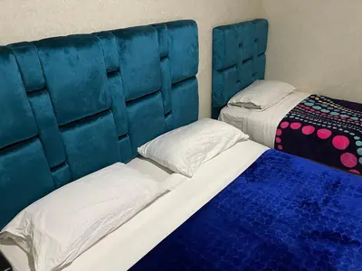 a bedroom with two beds and a blue headboard at Appartement 28 au 4 éme étage avec balcon ( POUR FAMILLE ) in Marrakech