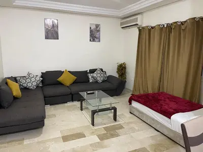 a living room with a couch and a table at Appartement 28 au 4 éme étage avec balcon ( POUR FAMILLE ) in Marrakech
