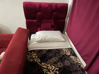 a small bed in a train with a red seat at Appartement 30 au 5 ème étage avec balcon ( POUR FAMILLE ) in Marrakech