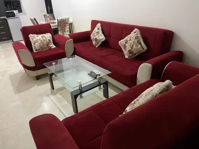 a living room with red couches and a glass table at Appartement 30 au 5 ème étage avec balcon ( POUR FAMILLE ) in Marrakech