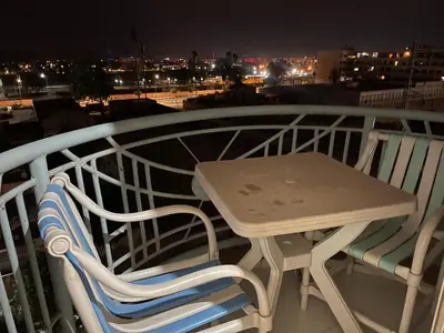 a table and chairs on a balcony at night at Appartement 30 au 5 ème étage avec balcon ( POUR FAMILLE ) in Marrakech