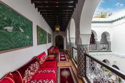 a hallway with red cushioned chairs in a building at Riad Maison Belbaraka in Marrakech