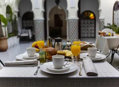a table with plates of food and glasses of orange juice at Riad Maison Belbaraka in Marrakech
