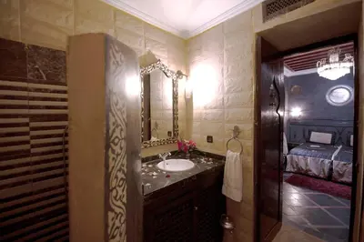 a bathroom with a sink and a large mirror at Riad Mille Et Une Nuits in Marrakech