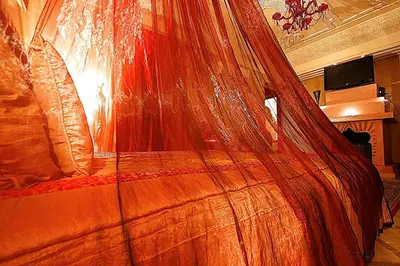 a bed with a net on top of it at Riad Mille Et Une Nuits in Marrakech