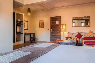 a bedroom with a bed and a living room at Riad Marrakech By Hivernage in Marrakech