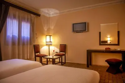a hotel room with a bed and a desk and a television at Riad Marrakech By Hivernage in Marrakech