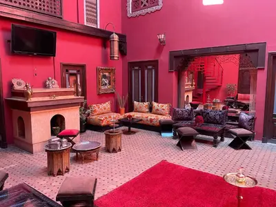 a large living room with a red wall at Riad Marrakech By Hivernage in Marrakech