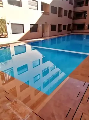 a large swimming pool in the middle of a building at Bitty Apartment in Marrakech