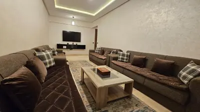 a living room with couches and a flat screen tv at Bitty Apartment in Marrakech