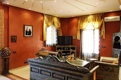 a living room with orange walls and a couch at Palais Dar Ouladna in Marrakech