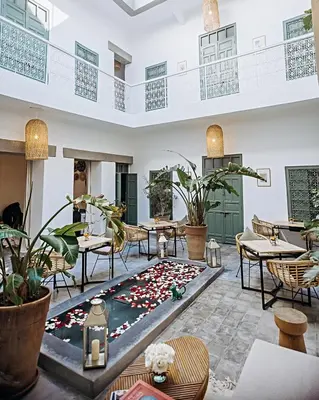 a restaurant with a pool in the middle of the room at Riad Villa Wengé & Spa in Marrakech