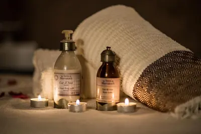 a group of candles and bottles on a bed at Riad Villa Wengé & Spa in Marrakech