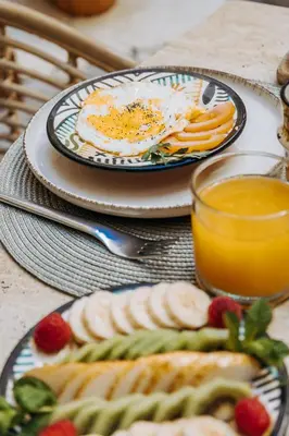 a table with plates of food and a glass of orange juice at Riad Villa Wengé & Spa in Marrakech