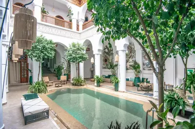an indoor pool in the courtyard of a building with trees at Riad Palais Calipau in Marrakech