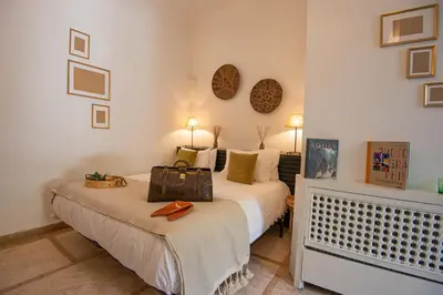 a bedroom with a bed with a bag on it at Riad Palais Calipau in Marrakech
