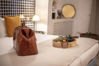a purse sitting on top of a bed with a bag at Riad Palais Calipau in Marrakech