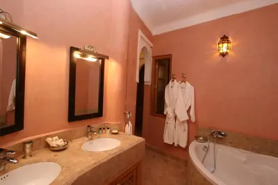 a bathroom with two sinks and a tub and a bath tub at Riad Palais Calipau in Marrakech
