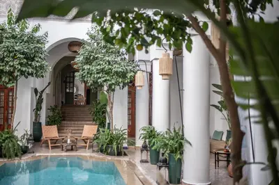 a courtyard with a swimming pool and trees at Riad Palais Calipau in Marrakech