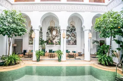 a pool in the lobby of a building with trees at Riad Palais Calipau in Marrakech