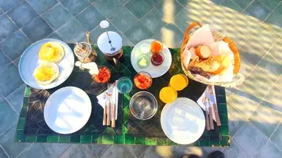a table with plates of food on top of it at Riad 2 chambres & Petit Déjeuner - Wifi - Top Location Médina in Marrakech