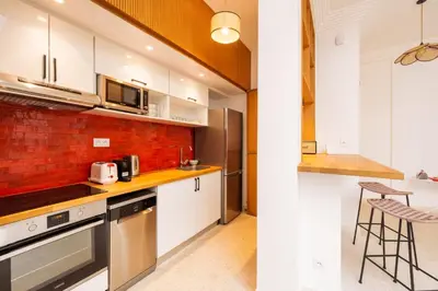 a kitchen with white cabinets and a brick wall at Riad 2 chambres & Petit Déjeuner - Wifi - Top Location Médina in Marrakech