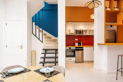 a kitchen and a living room with a table and a staircase at Riad 2 chambres & Petit Déjeuner - Wifi - Top Location Médina in Marrakech