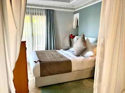 a bedroom with a bed with blue walls and curtains at Pavillon du Golf - Palmeraie suites in Marrakech