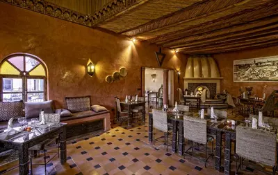 a restaurant with tables and chairs and a couch at Hotel Kasbah Le Mirage & Spa in Marrakech
