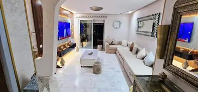a living room with a couch and a mirror at Magnifique appartement à Riad Garden in Marrakech