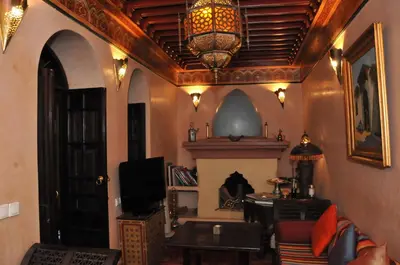 a living room with a fireplace and a chandelier at Riad Adriana in Marrakech