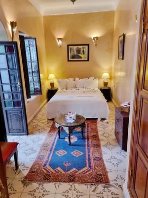 a bedroom with a bed and a table in a room at Riad Adriana in Marrakech