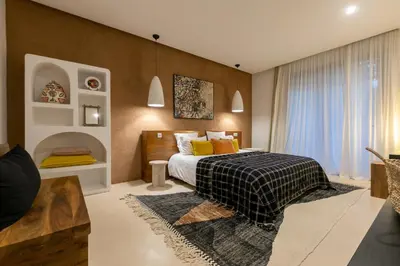 a bedroom with a bed with yellow pillows at Villa Ecolodge DAR LOUMA in Marrakech
