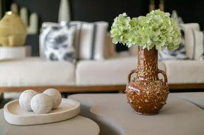 a vase with flowers and rocks on a table at Villa Ecolodge DAR LOUMA in Marrakech