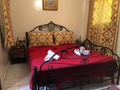 a red bed with pillows on it in a room at Riad Jasmine in Marrakech