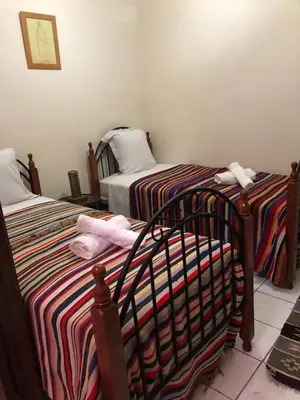 a bedroom with two twin beds with striped sheets at Riad Jasmine in Marrakech