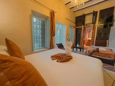 a person sitting on a bed in a room at Riad L'Orchidée Suites & Spa in Marrakech