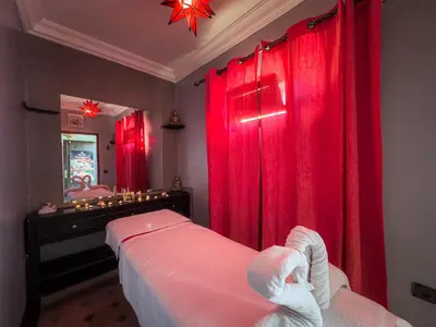 a bedroom with red curtains and a bed and a mirror at Riad L'Orchidée Suites & Spa in Marrakech