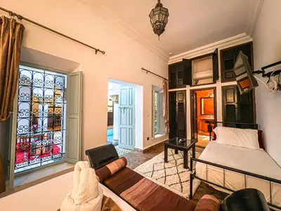 a living room with a bed and a couch at Riad L'Orchidée Suites & Spa in Marrakech