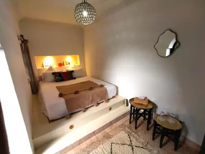 a bedroom with a bed and a table and chairs at Riad Dowaya in Marrakech